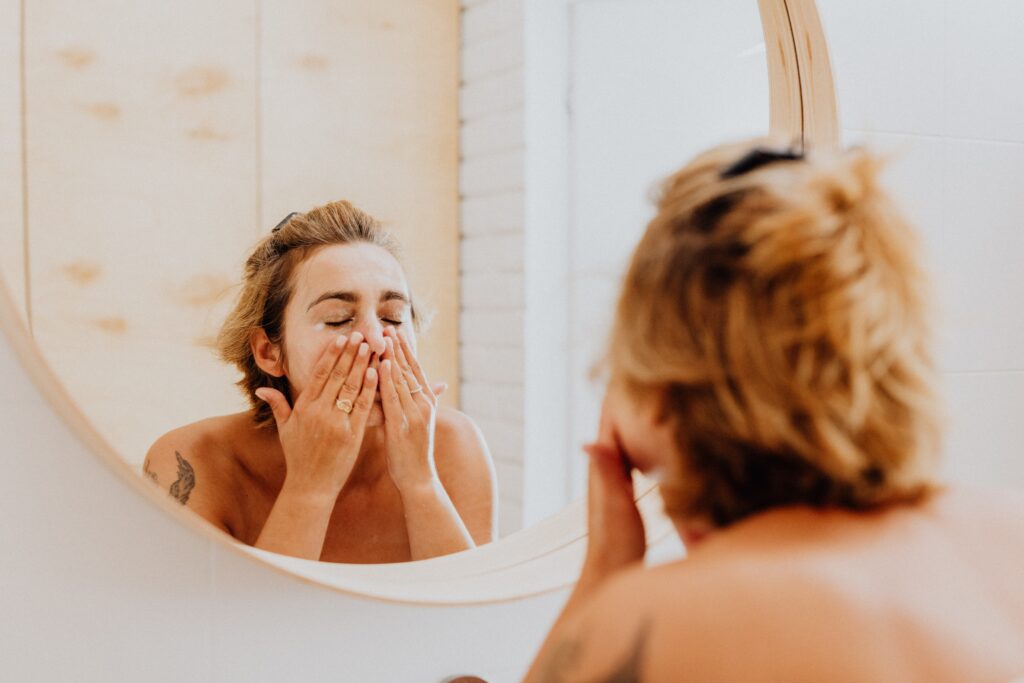 woman washing her face to steam